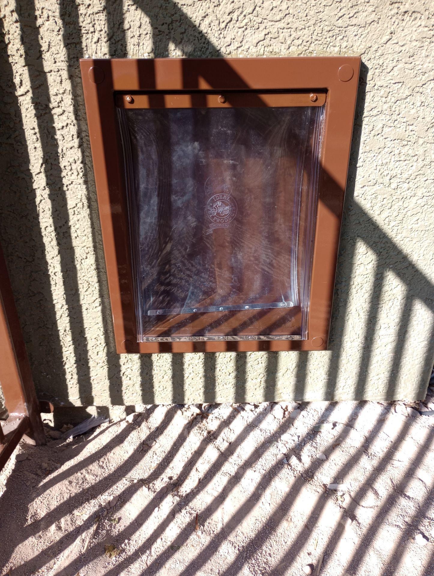 Small square window with a brown frame set into a textured exterior wall.